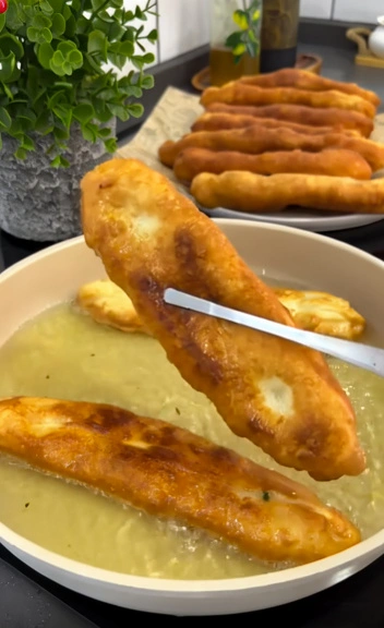 Potato stuffed dough frying in hot oil until golden brown