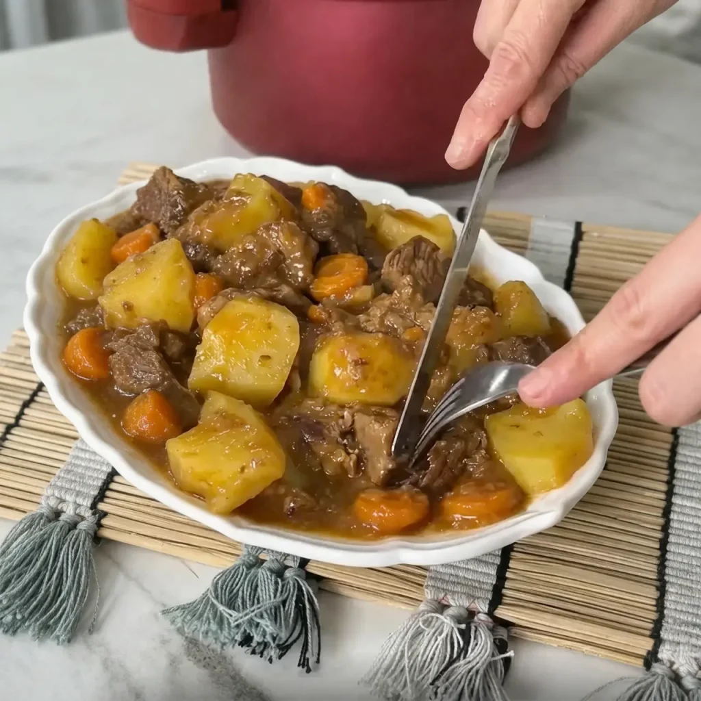 Beef stew with potatoes served in a bowl with carrots and rich savory sauce