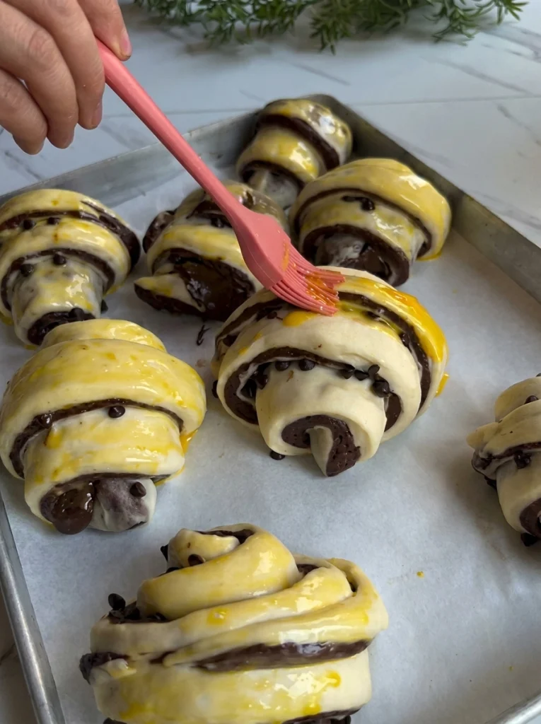Cross-section of chocolate croissant roll showing marbled dough and melted chocolate filling