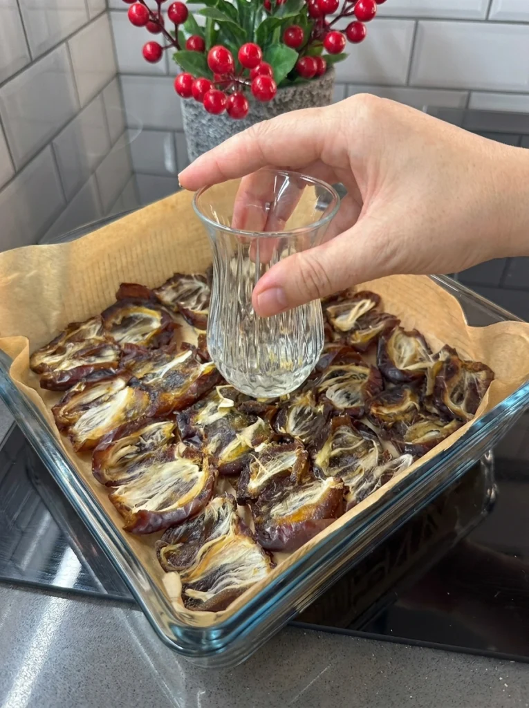 Arranging pitted dates in a tray to prepare the base for chocolate date bars recipe