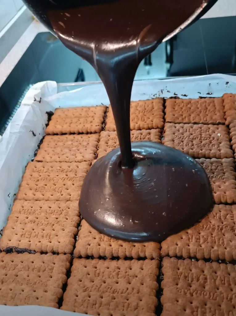 Smooth dark chocolate ganache being stirred in a saucepan