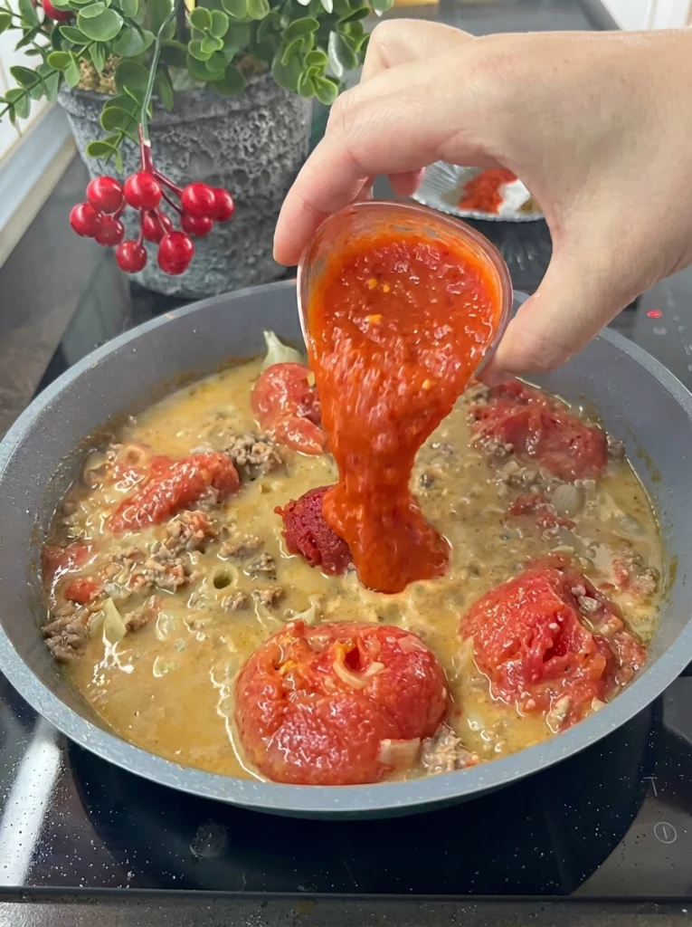 Homemade tomato sauce cooking with onions and garlic for spaghetti pasta casserole