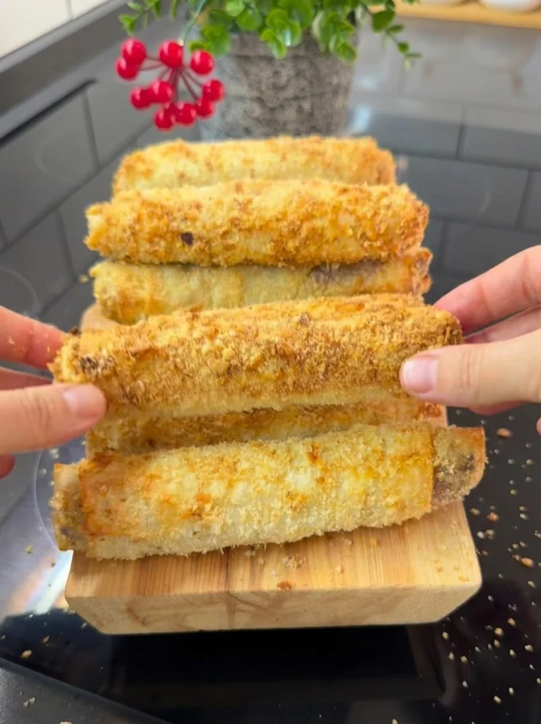 Cross-section of crispy pastry roll showing melted cheese and meat filling
