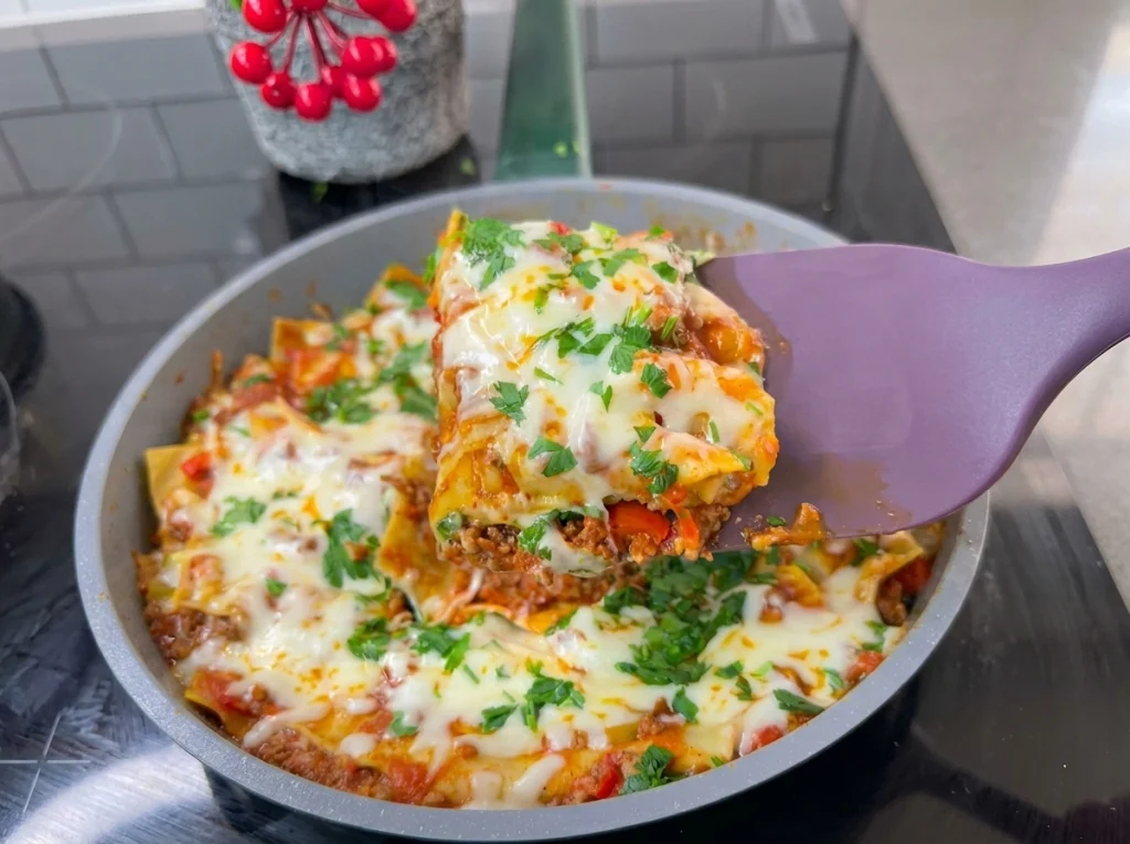 Easy one-pan lasagna topped with melted cheese and parsley in a skillet