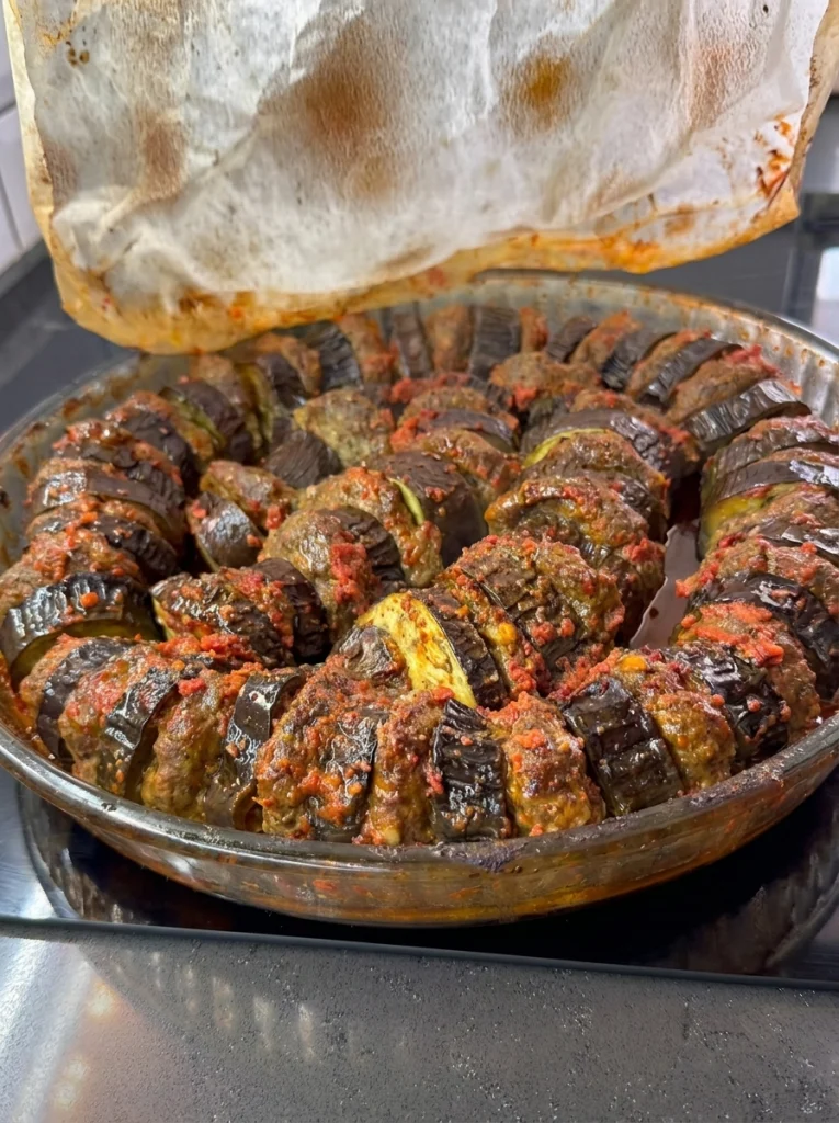 Close-up of baked eggplant kebab served with tomato sauce