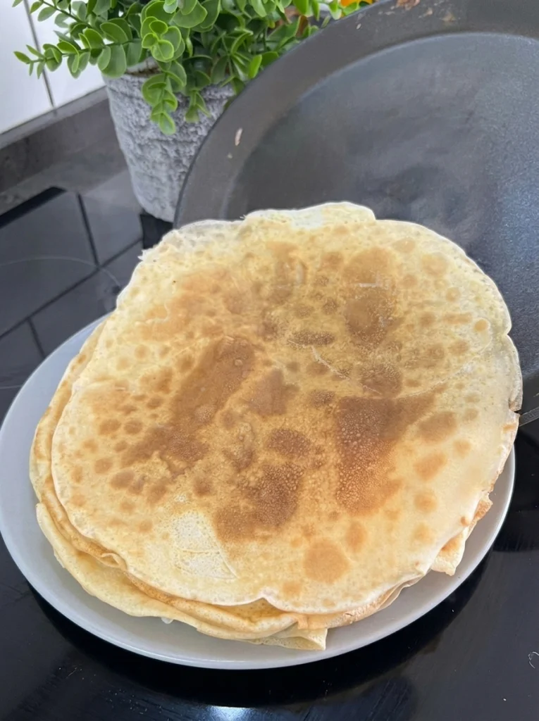 Layered fake lasagna made with thin crepes, beef filling, and béchamel sauce