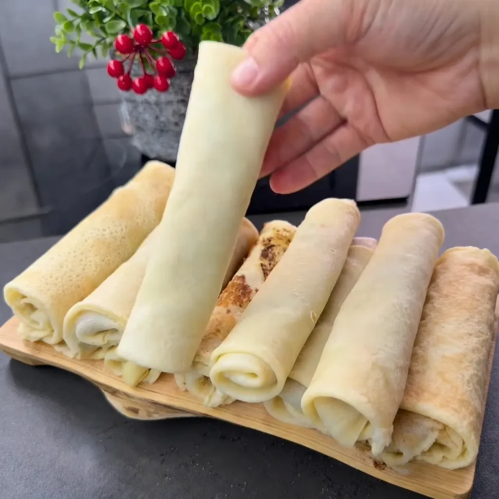 Adding minced meat filling to a savory pancake before folding