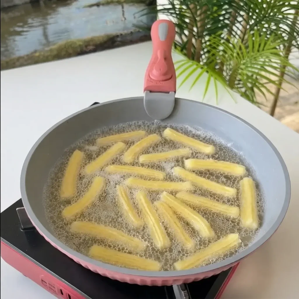 Golden churros frying in hot oil