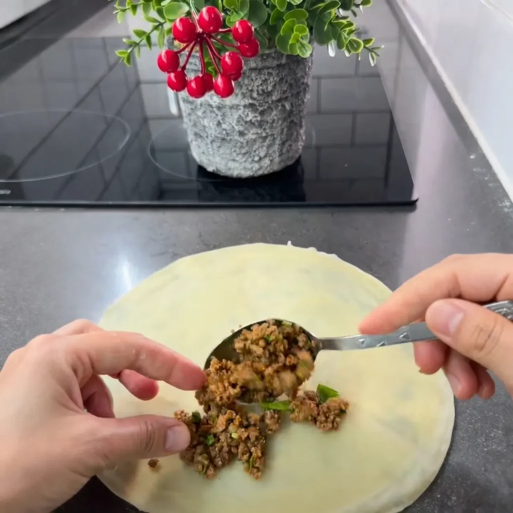 Seasoned minced meat and chopped onion cooking in a pan