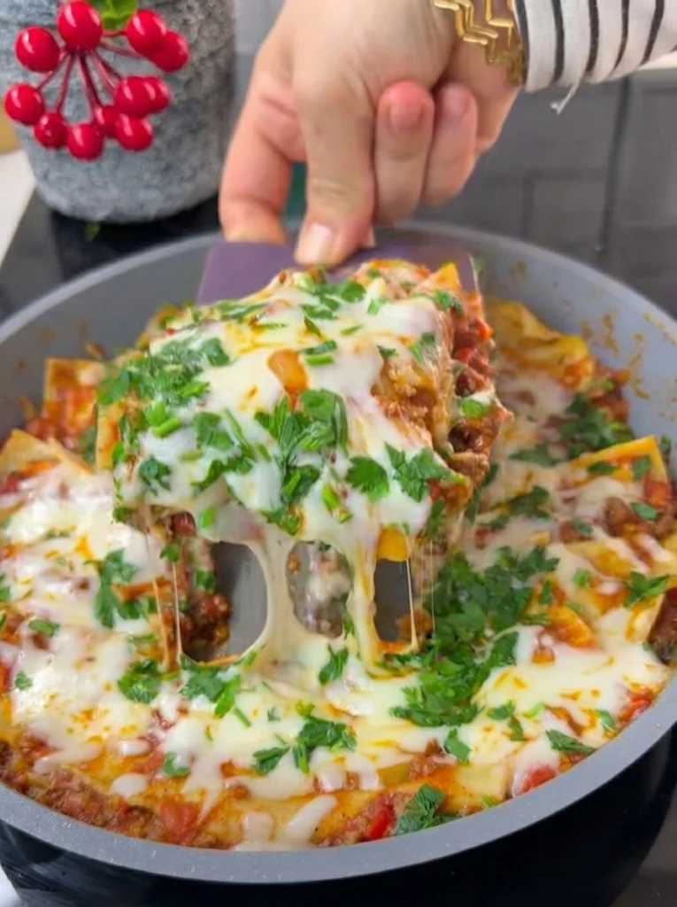 Close-up of one-pan lasagna garnished with grated cheese and fresh parsley
