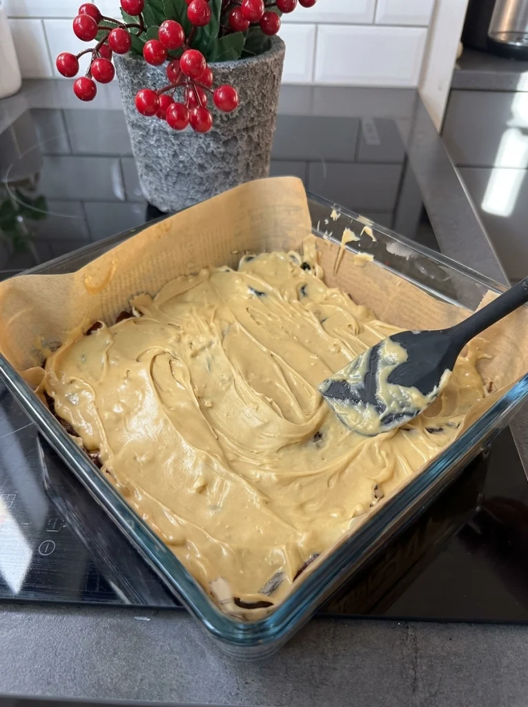 Spreading creamy peanut butter over dates for no-bake chocolate date bars