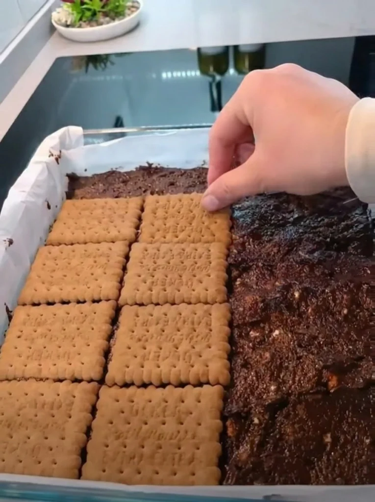 Pouring chocolate ganache over no-bake biscuit cake