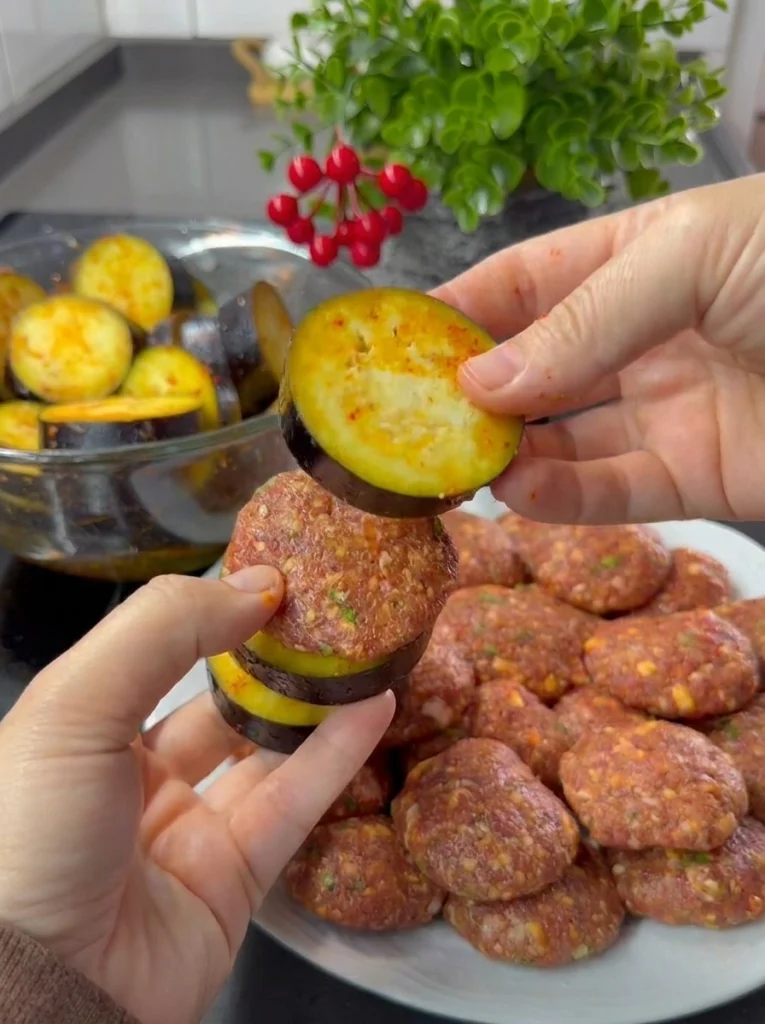 Hand-shaped meatballs ready for baked eggplant kebab