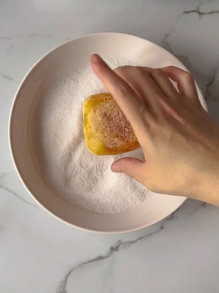 Fresh vanilla donuts coated with granulated sugar
