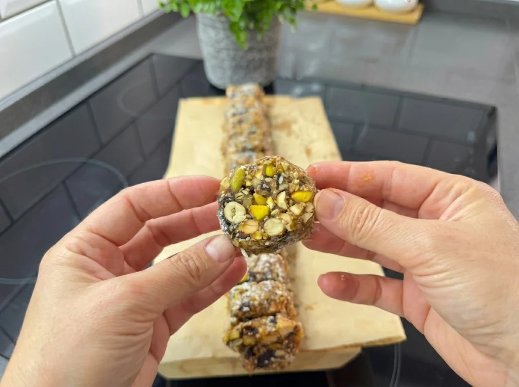 Sugar-free gluten-free date bars coated with coconut and sliced for serving