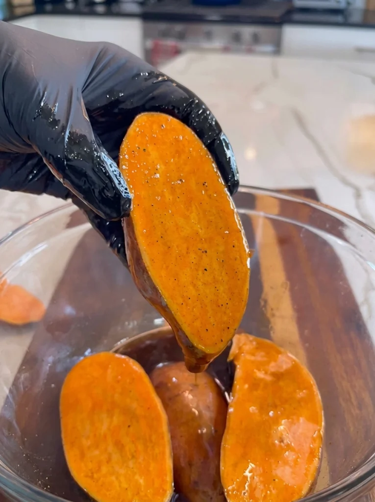 Brushing maple cinnamon glaze onto sweet potato halves