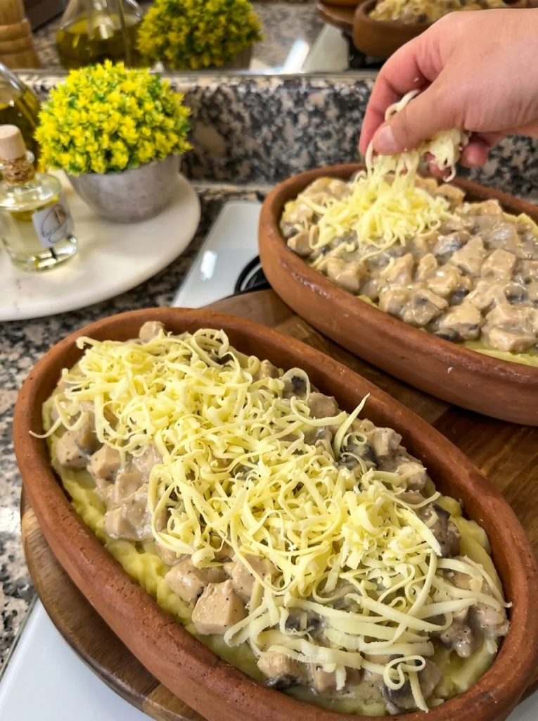 Unbaked casserole topped with grated cottage cheese, ready for the oven