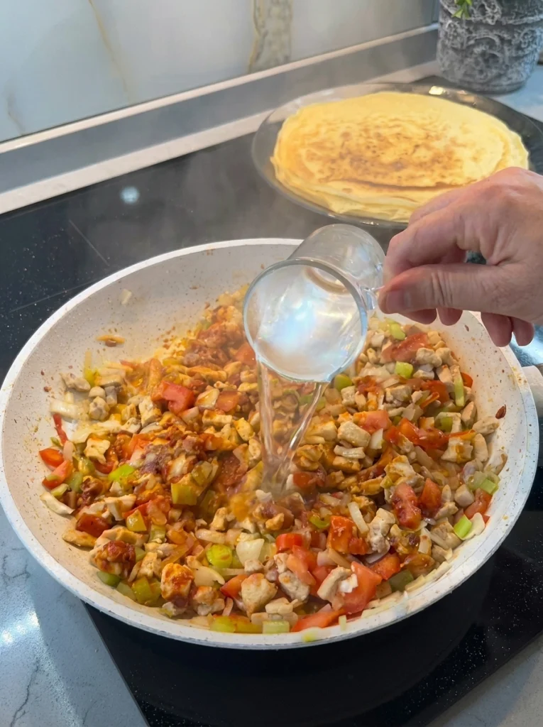 Spiced chicken and vegetable filling cooking in a pan