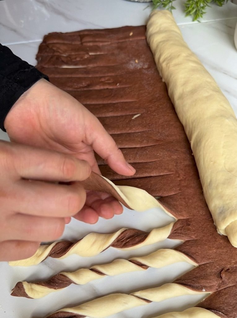 Rolling out chocolate dough over plain dough for swirl bread