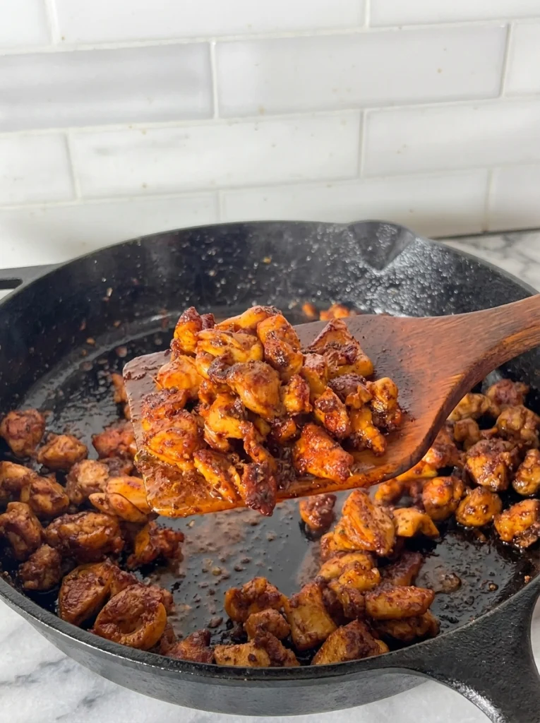 Chopped cooked chicken fajita pieces in a skillet