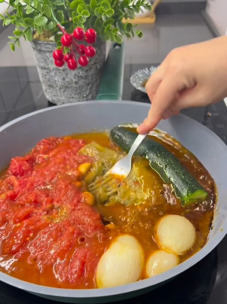 Onions, tomatoes, zucchini, and eggplant simmering together in a pan