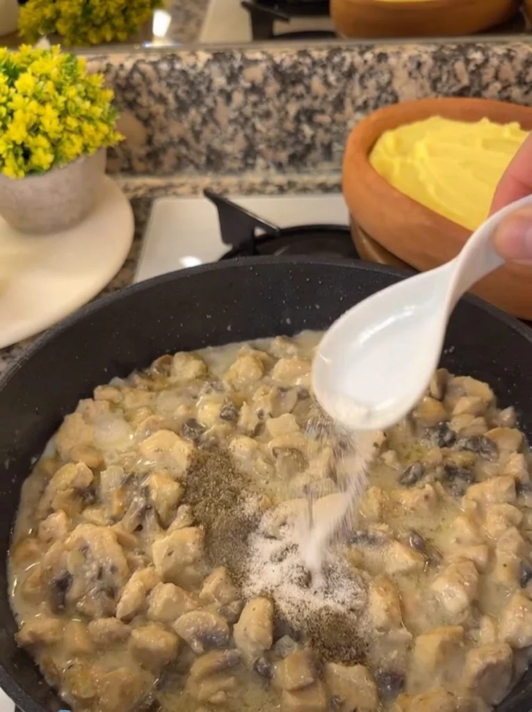 Diced chicken breast frying golden brown in a skillet