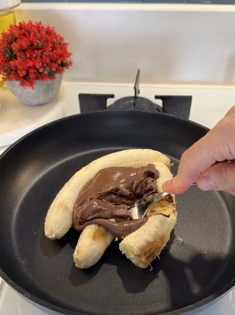 Mashing banana with chocolate spread in a bowl
