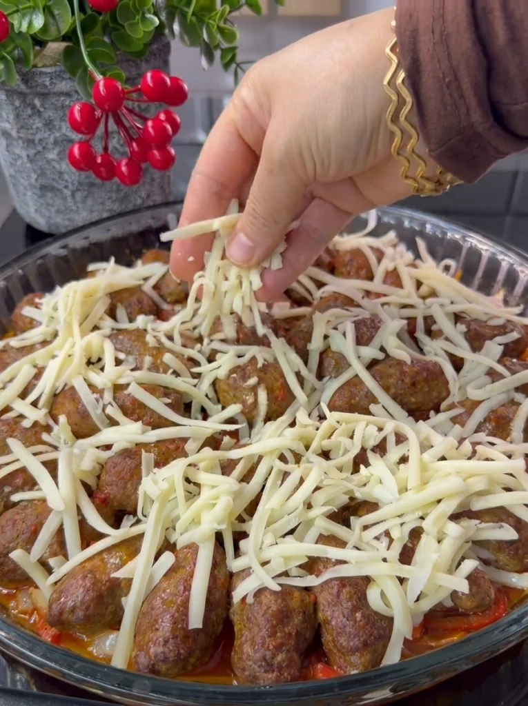 Baked meatballs with vegetables topped with golden melted cheese