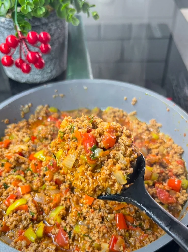 Spiced minced meat filling cooking in a pan for stuffed eggplant