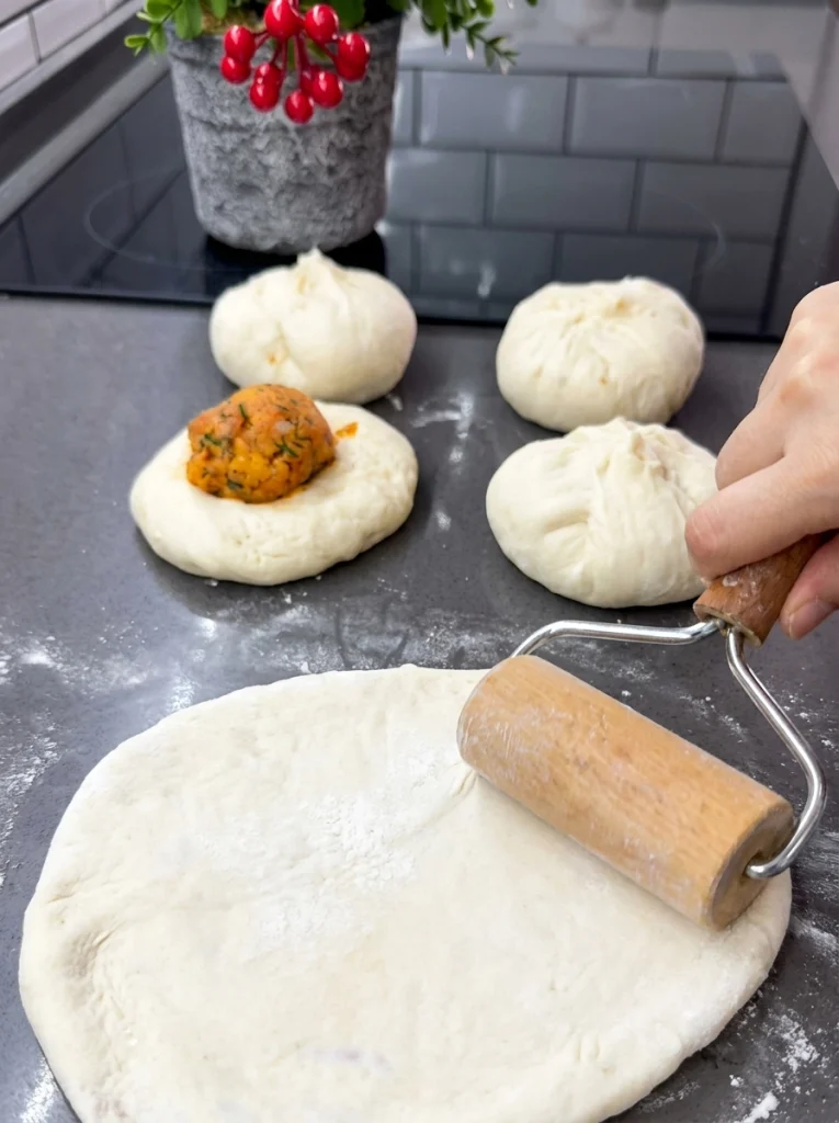 Rolling out stuffed dough into a flat round before cooking