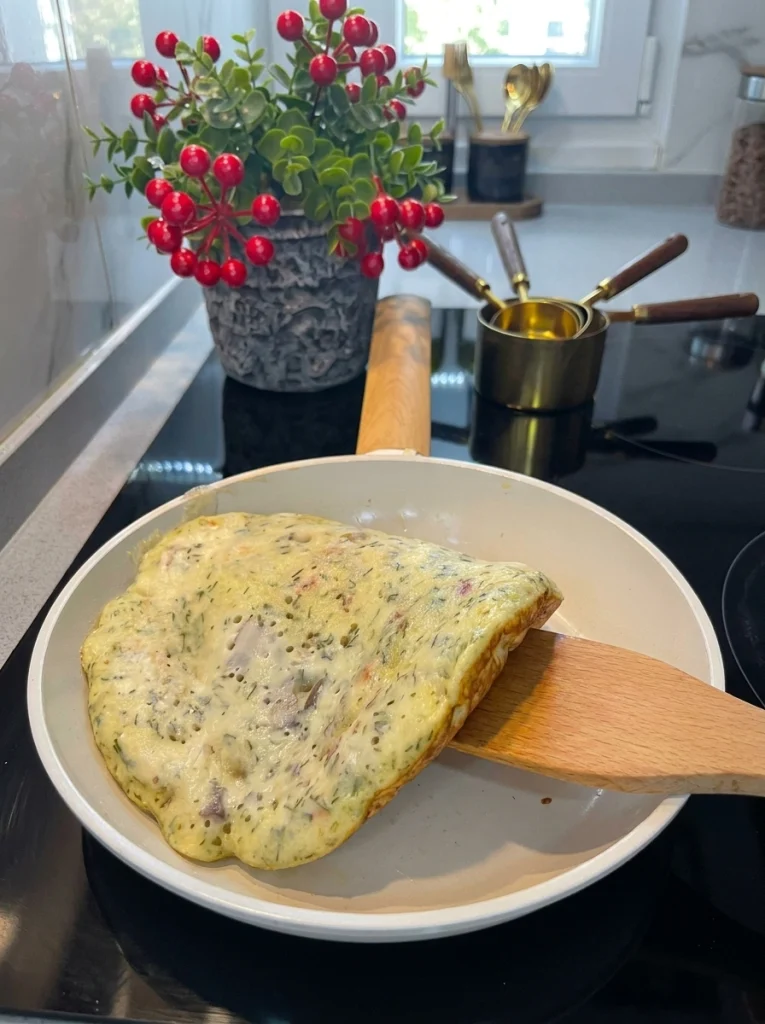 Savory pancake batter cooking in a non-stick pan on low heat