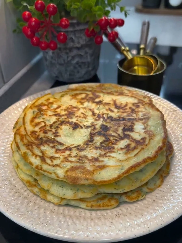 Sliced savory pancake with melted cheese and sausage served on a plate