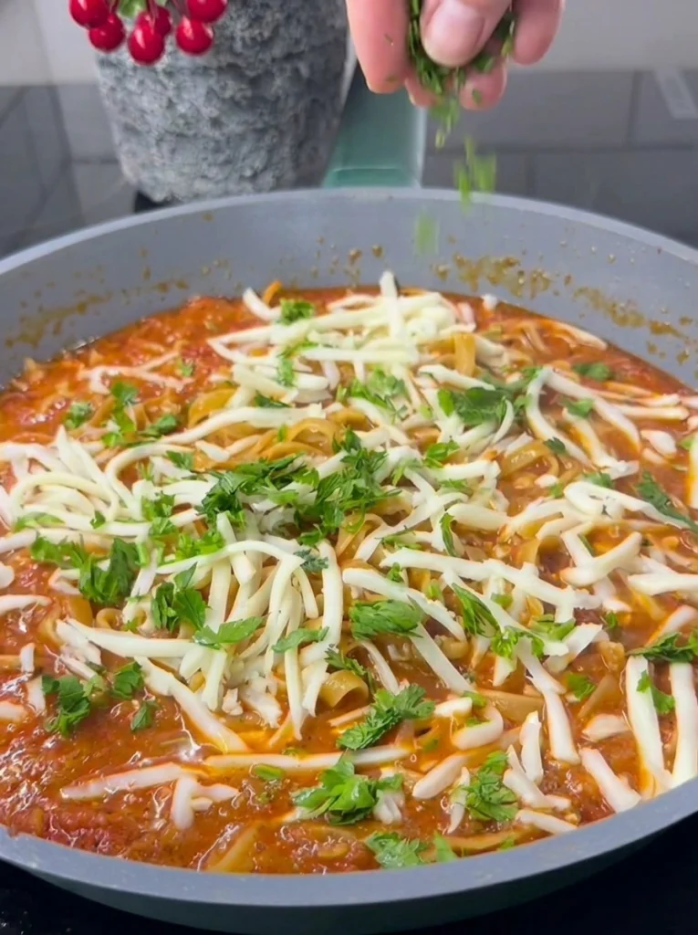 Close-up of tomato vegetable pasta topped with melted cheddar cheese