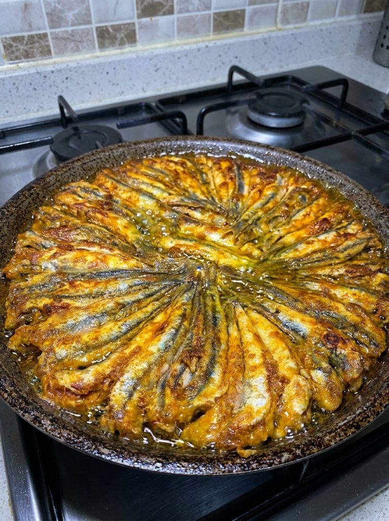 Close-up of crispy Turkish Anchovy Fry with lemon wedge